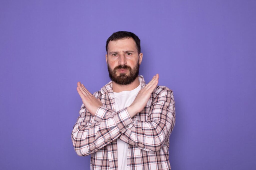 1 Unstoppable Canadian Bank Stock to Buy Right Here, Right Now man crosses arms and hands to make stop sign